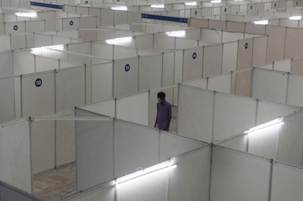 A health worker prepares the Chennai Trade Centre which will soon be converted into a 600-bed isolation ward, Chennai, India on 14 April, 2020, by Arun SANKAR / AFP.