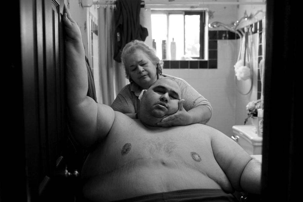 Photojournalist Lisa Krantz documented one man's losing battle with obesity. Hector Garcia Jr. weighs over 600 pounds in this image. Moving from one room to another has become nearly impossible for him, so his mother, Elena, watches over him. This four-year photographic account titled "A Life Apart: The Toll of Obesity" is accompanied by the heartbreaking testimonies of Hector and his loved ones