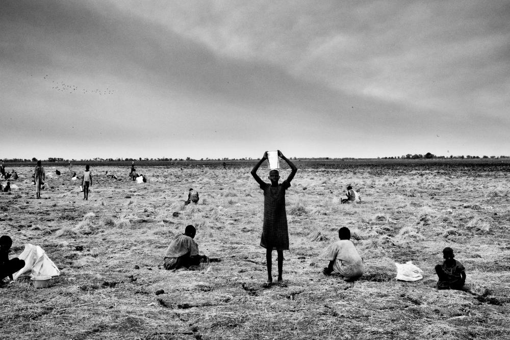 Magnum photographer Matt Black took this image of the people of Gayiel, South Sudan, searching for spilled grain after a World Food Programme airdrop in 2016