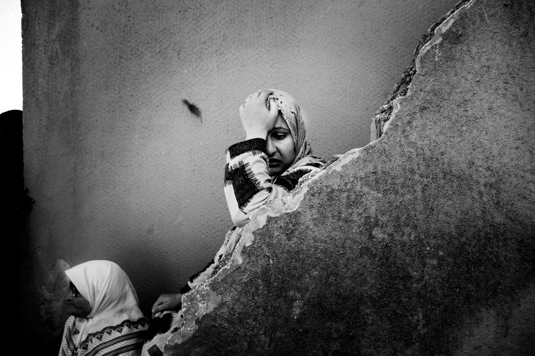 LEBANON. Ramesh. A woman desperate to flee stands behind what’s left of her home. July 2006. Paolo Pellegrin / Magnum Photos