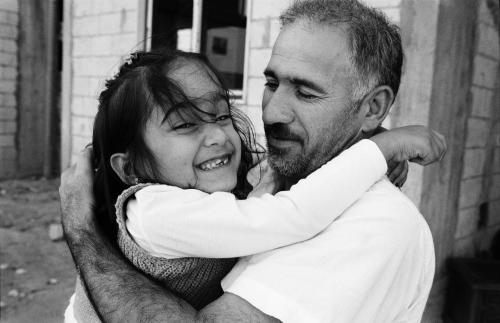 On this picture by Giles Duley taken in 2016. Aya, a young Syrian refugee, hugs her father as they prepare to be resettled from Lebanon to France.  