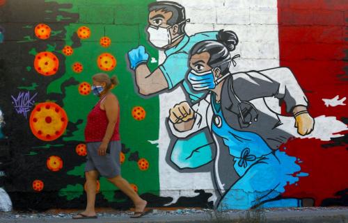 A woman walks past a coronavirus-related mural painted by artist Mick Martinez in Ciudad Juarez, state of Chihuahua, Mexico, on 19 May 2020. Photography Herika Martinez / AFP
